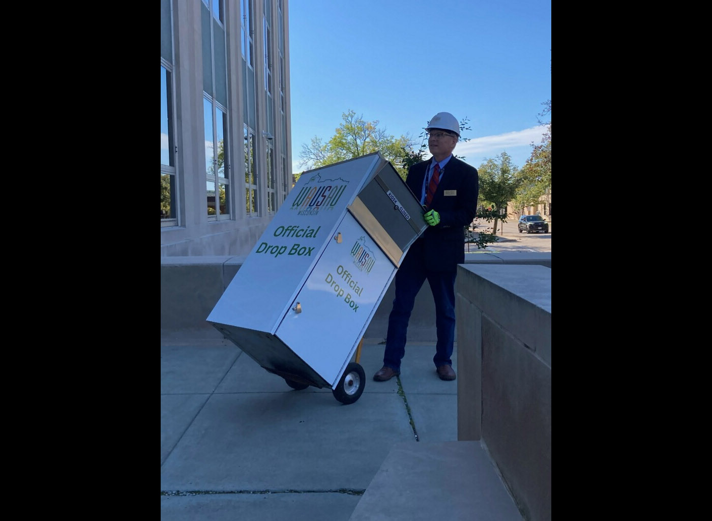 Wausau Mayor Doug Diny removes a ballot drop box from outside Wausau City Hall on Sept. 22, 2024.