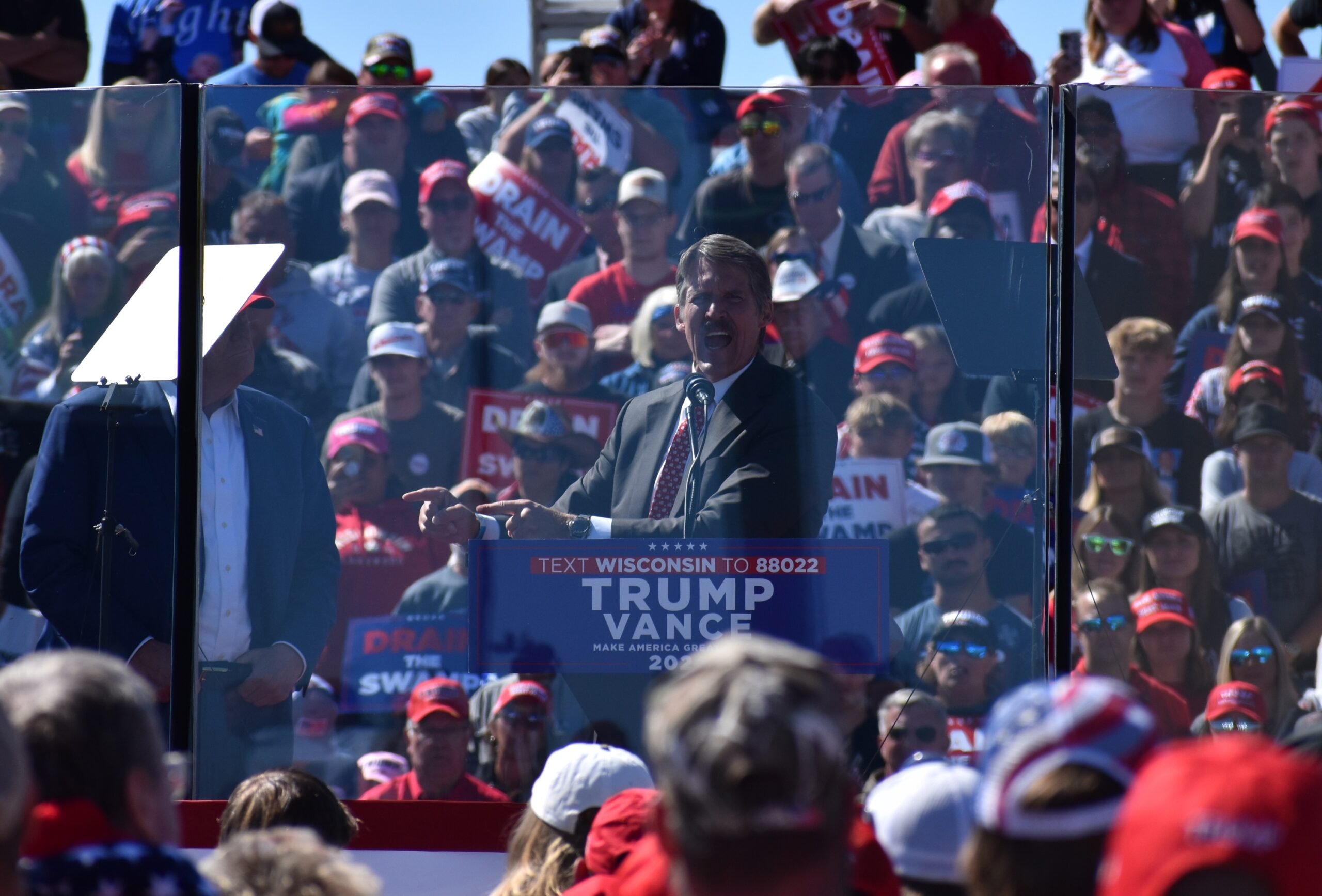 Republican U.S. Senate candidate Eric Hovde speaks at the Trump rally in Mosinee, while Trump looks on.