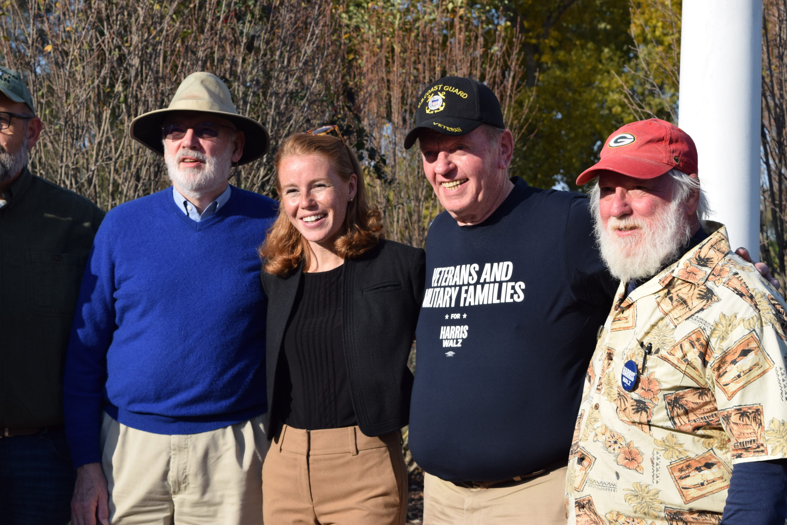 Cooke and several men smile for a photo in a park