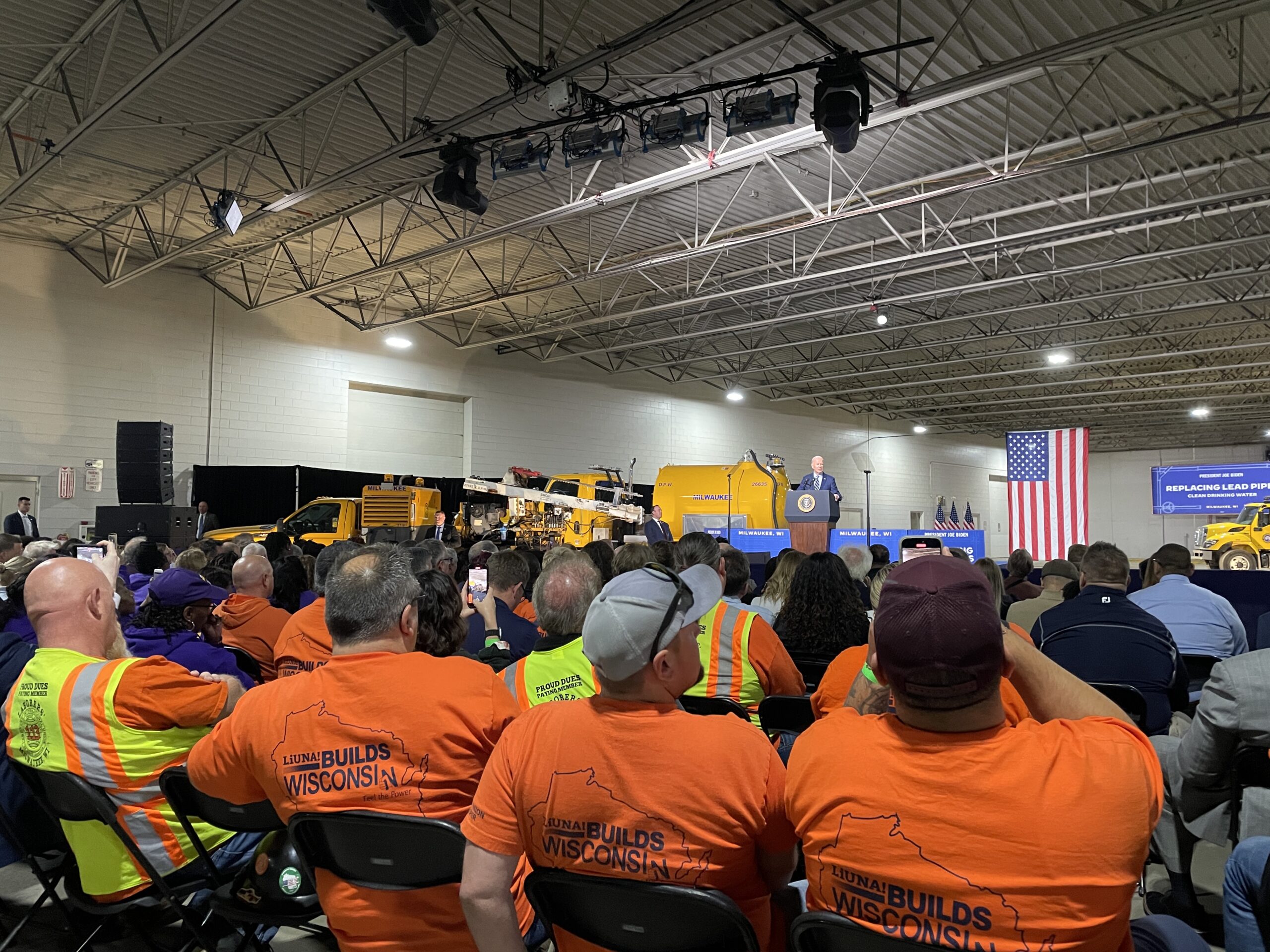 Members of the Laborers' International union watch President Joe Biden's announcement of a new EPA rule requiring replacement of all lead water services lines by 2037, in Milwaukee on Oct. 8, 2024.