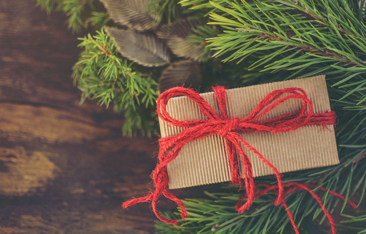 Brown paper wrapped gift under an evergreen tree.