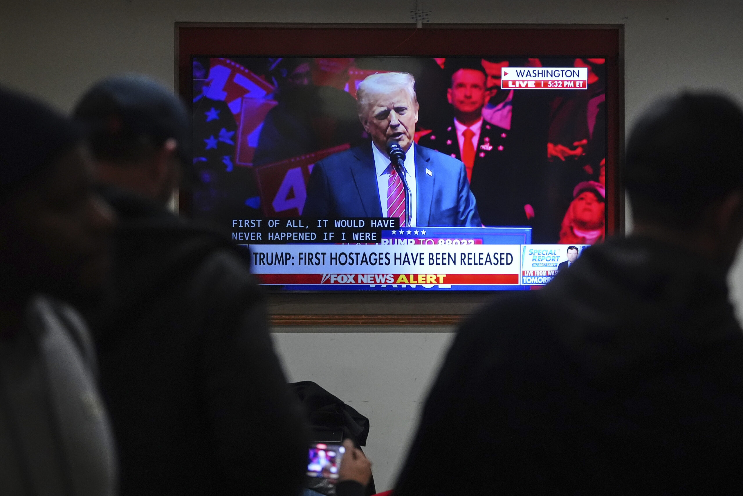 People inside of a restaurant watch President-elect Donald Trump speak during a rally ahead of the 60th Presidential Inauguration shown on a TV, Sunday, Jan. 19, 2025, in Washington. (AP Photo/Julio Cortez)