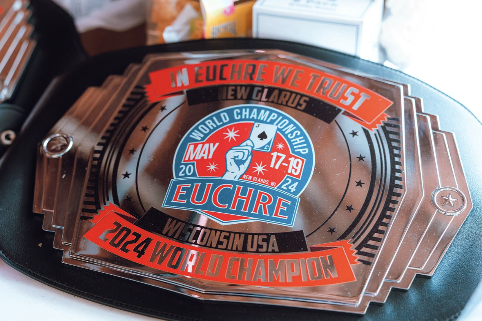 Close-up of a championship belt for the 2024 Euchre World Championship, held May 17-19 in New Glarus, Wisconsin, USA, with the slogan In Euchre We Trust.